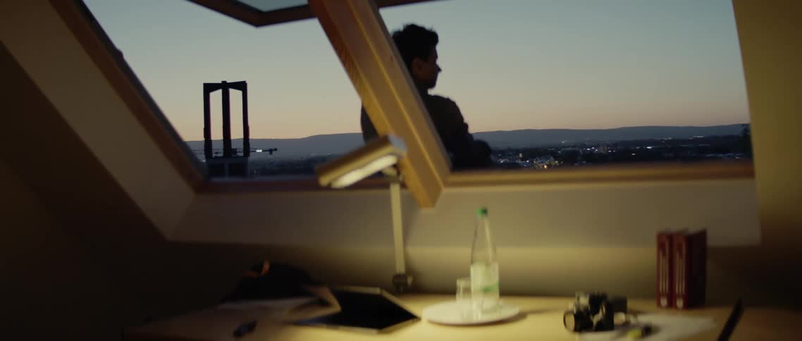 A person sits outside an open window