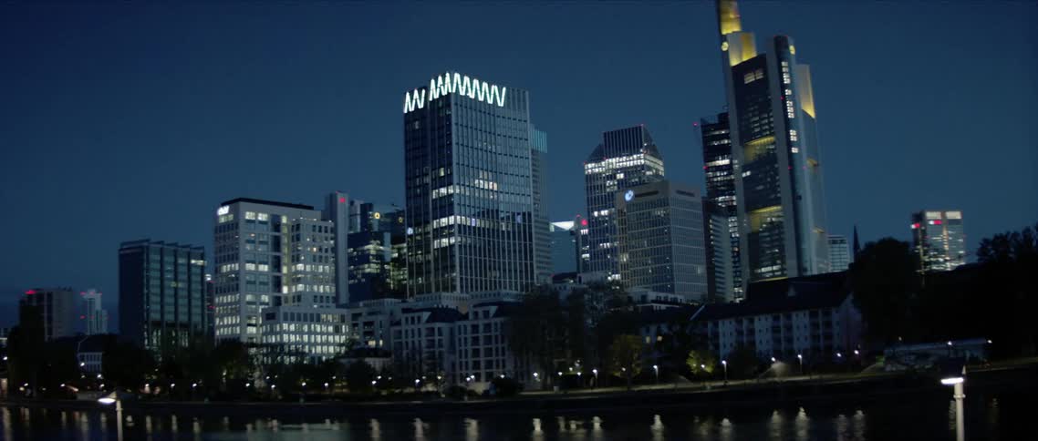 City is lit by lights at night reflecting over the river