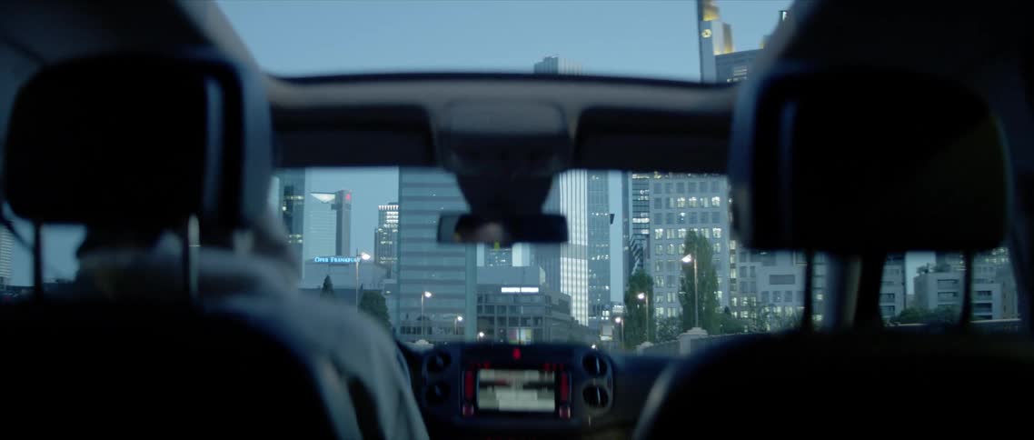 A car is driving through a downtown city