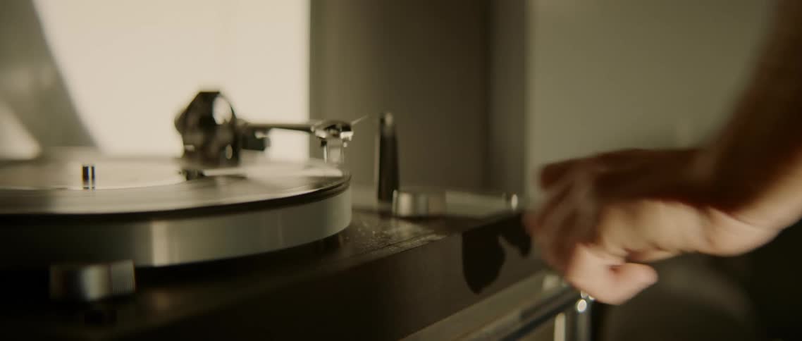 A person adjusting a knob on a record player