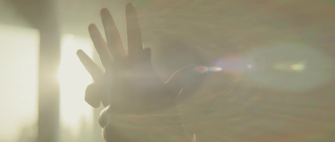 A person is moving their hands by a window with sunlight coming in