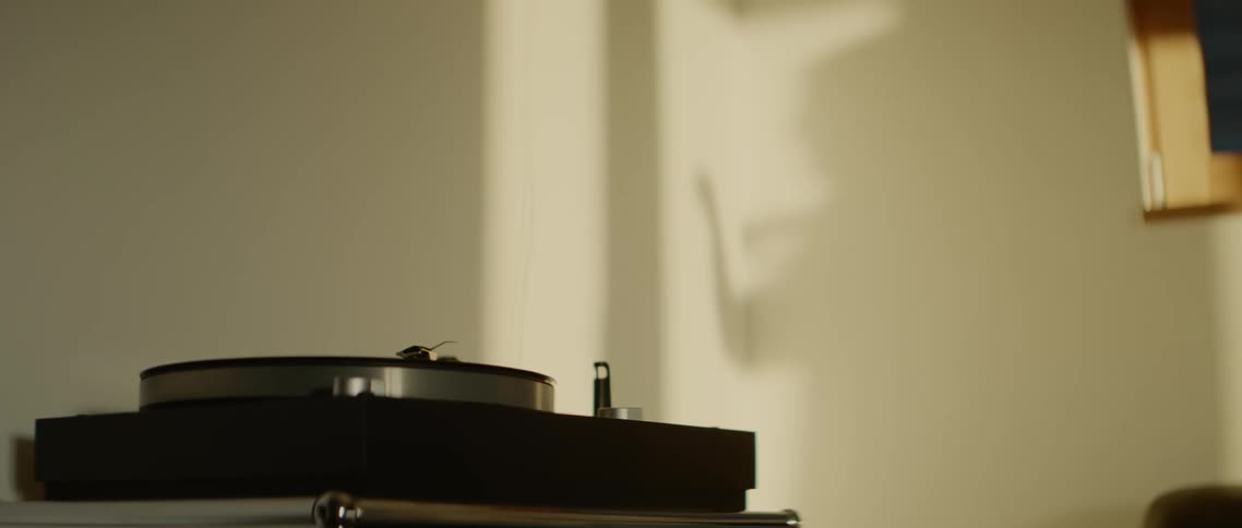 A room with a record player with a person shadow dancing on the wall