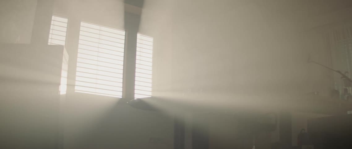 A room with a table with a window with sunlight shining through