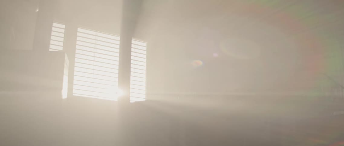 A room with a table with a window with sunlight shining through