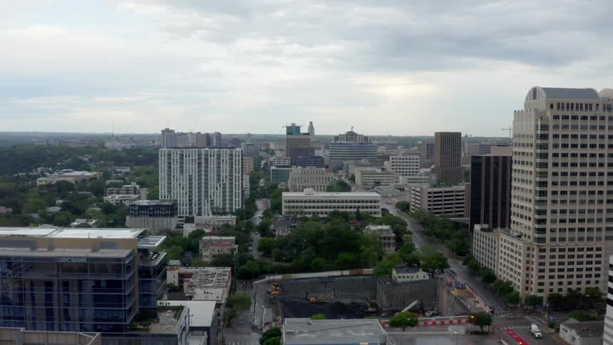 A city with buildings roads vehicles and trees