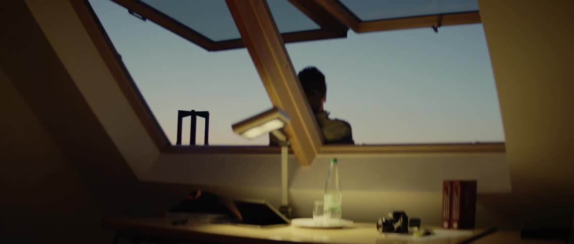 A person stands outside an open window