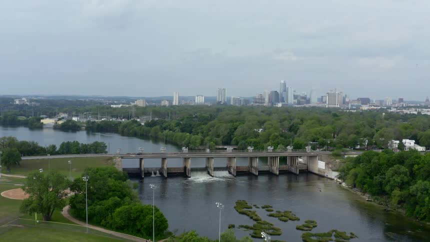 Cars drive across a bridge with the downtown skyline in the distance