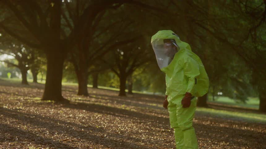 A man is wearing a protective suit and is outdoors