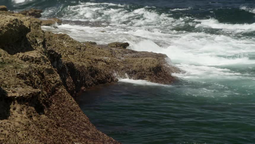 Water is crashing on the rocks by the shore