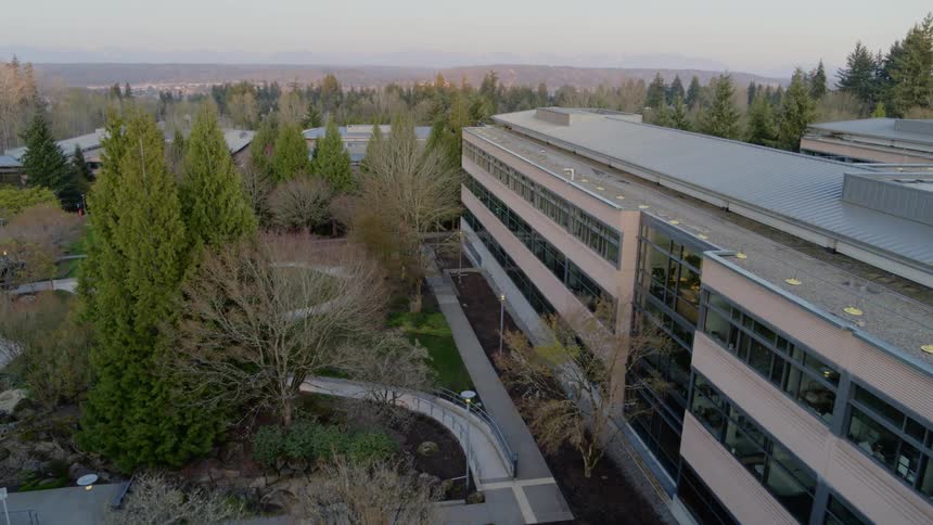 Flying toward an office building surrounded by trees