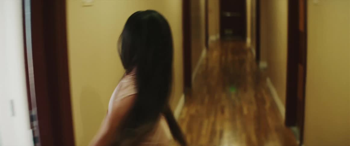 Woman opens the door and runs along the hotel hallway