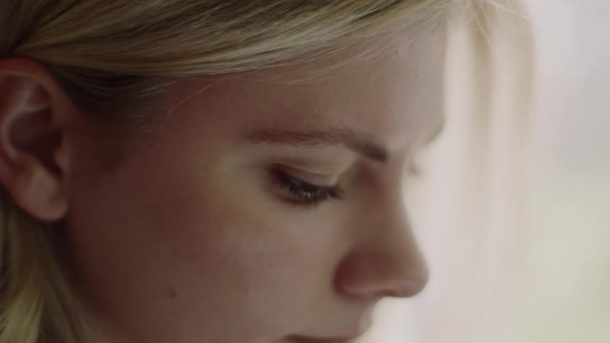A blonde haired female by a window