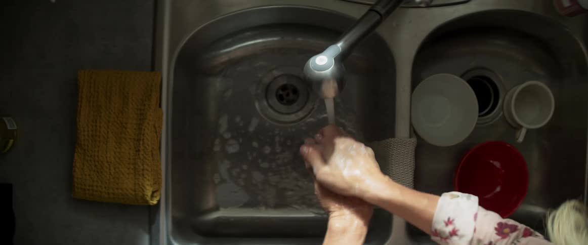A woman is washing her hands in a sink