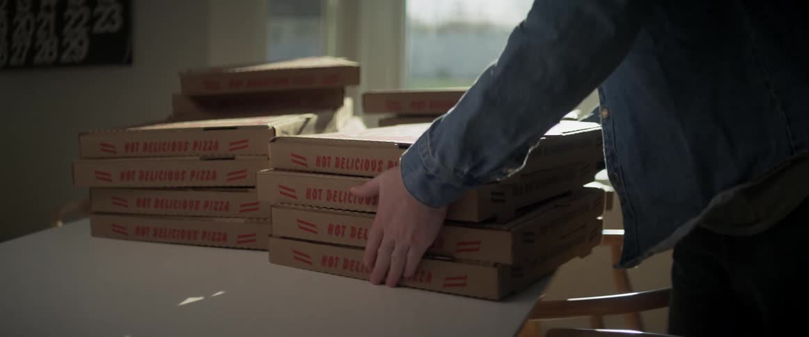 A person is picking up boxes of pizza