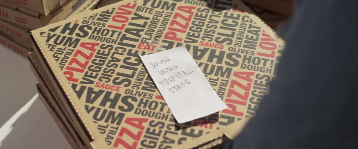 Man grabs boxed pizzas for delivery