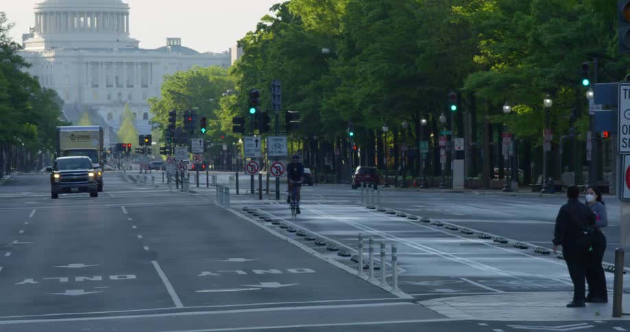 Pedestrians cross street in front of the united states capitol