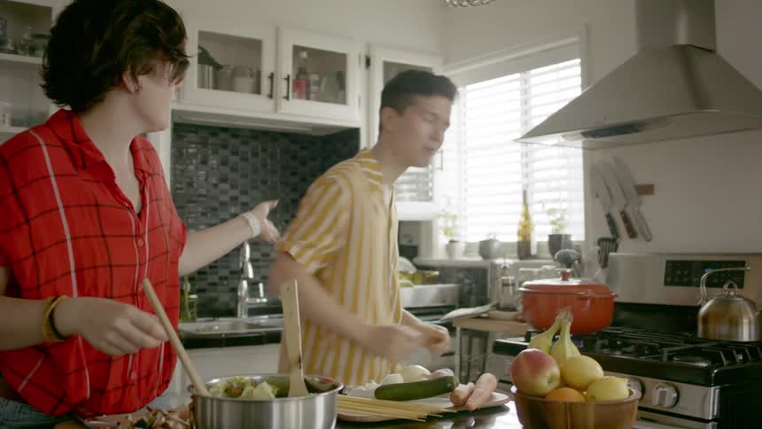 A mom and son cook in the kitchen