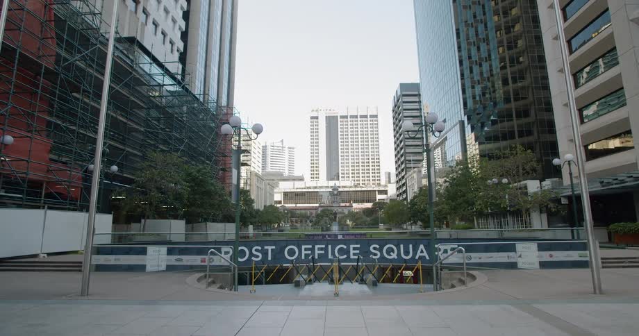 Steps lead to a post office that sits below tall skyscrapers