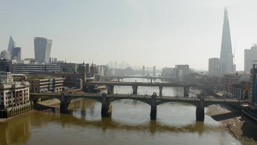A bridge over a lake with the city skyline in the distance