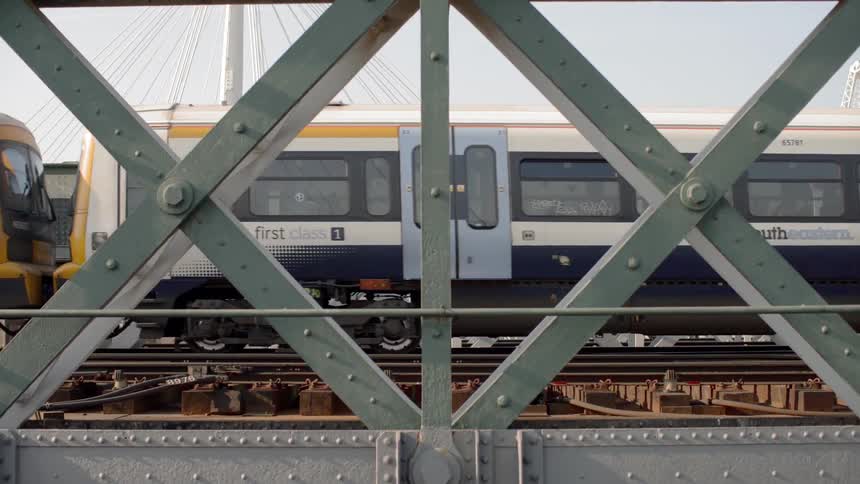 An empty train travels on elevated tracks on a sunny day