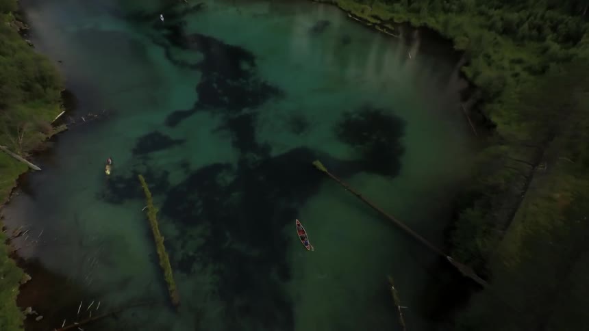 Aerial view of two boats paddling down a river