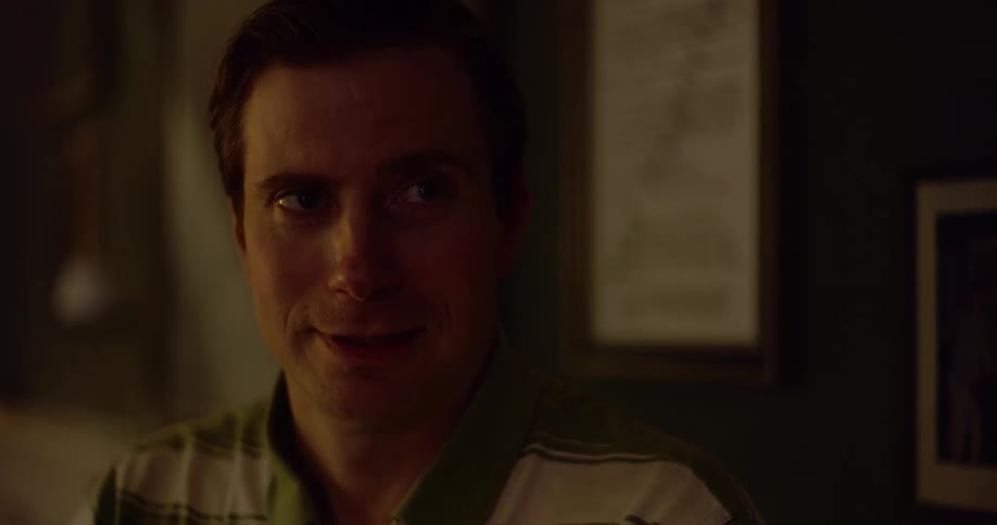 A man smiles and looks at something