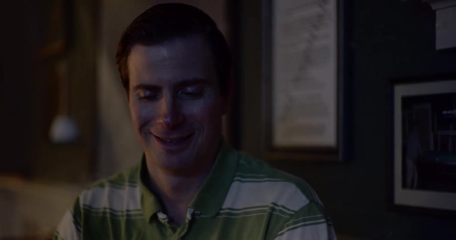A man laughs nervously while sitting