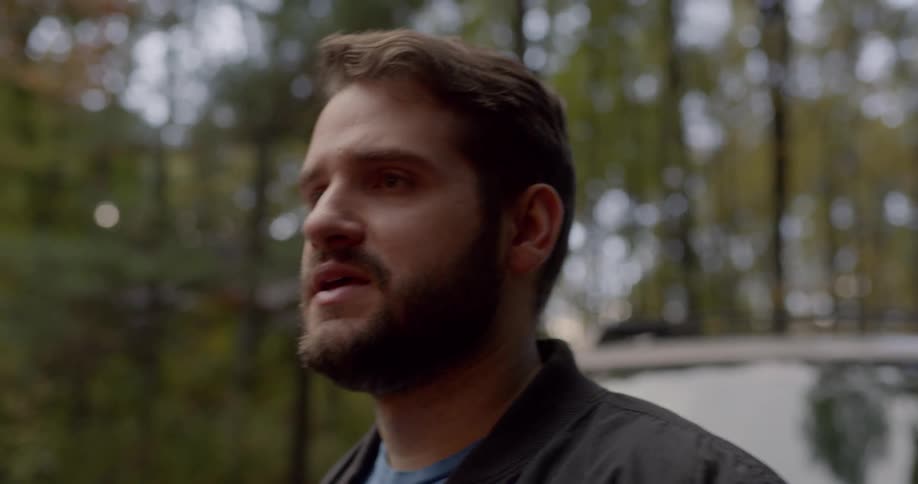 A man takes a deep breath while standing outside