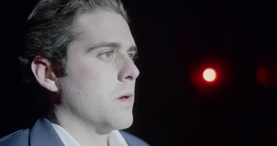 A man opens his eyes on stage