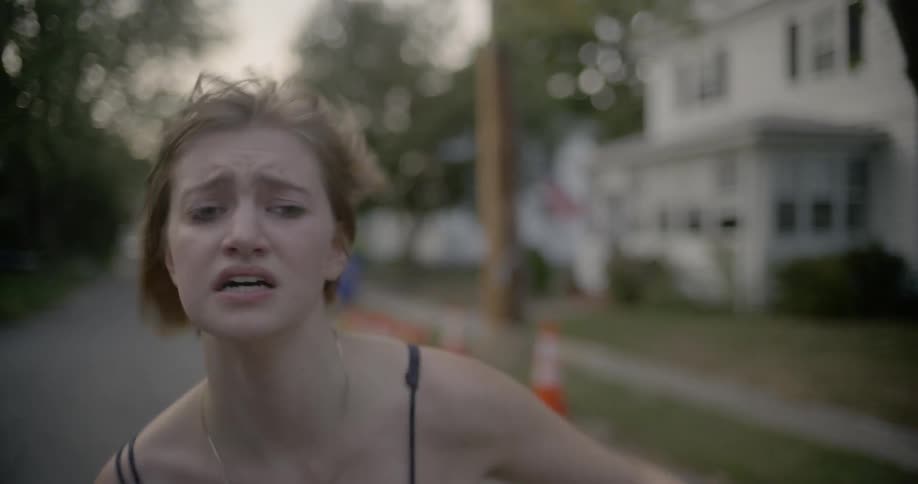 A woman runs down a street looking upset