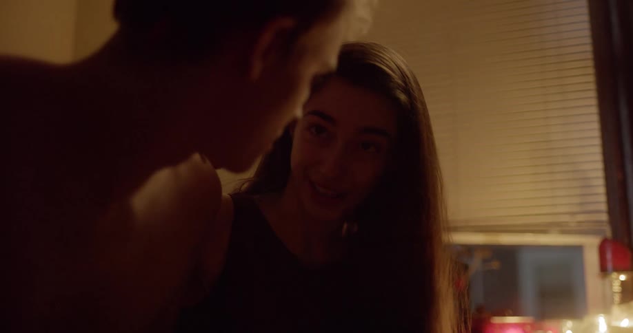Two teenagers look at each other longingly