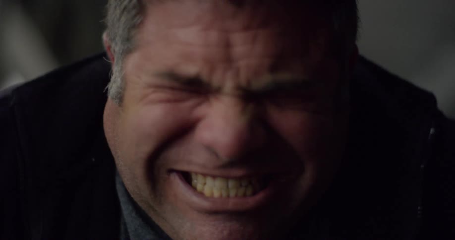 A man grits his teeth together and appears to be ready to yell