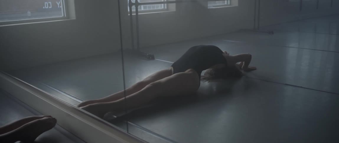A woman in black stretches on the floor