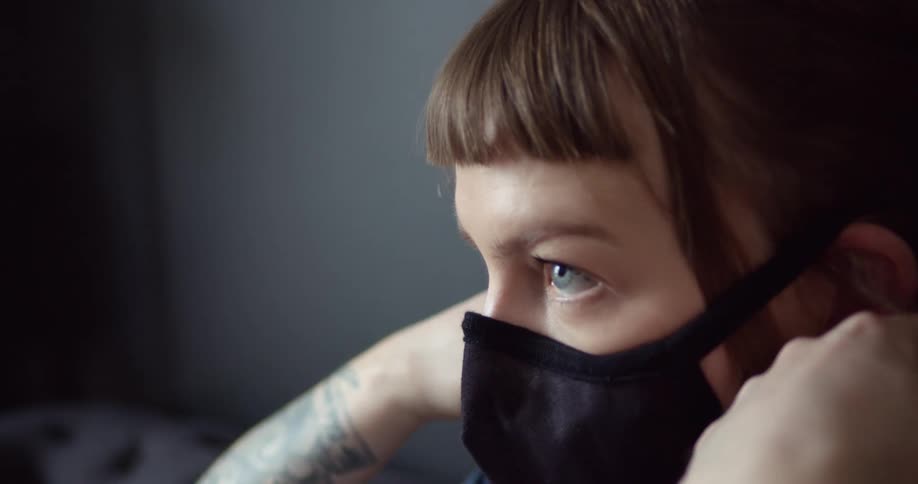 A woman taking off her face mask