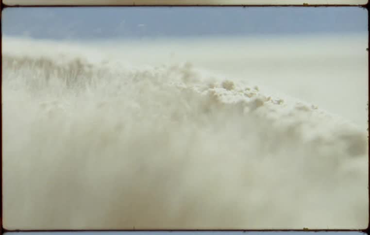 Dust rises as flour is milled in a large container