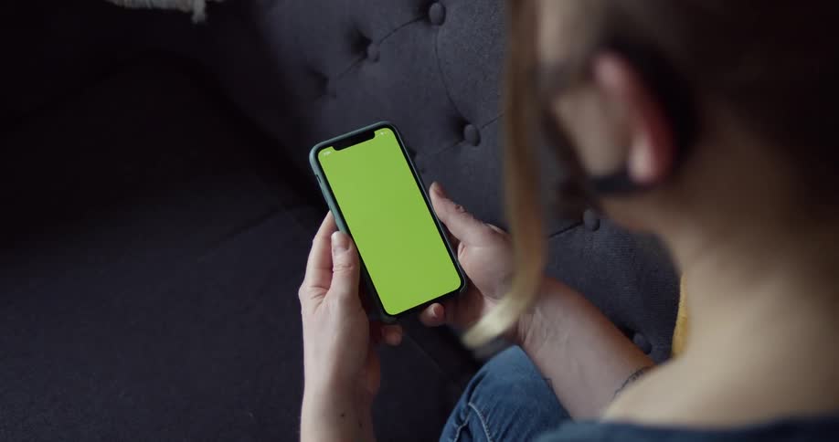 A Woman looks at her phone as she waits for an app to open