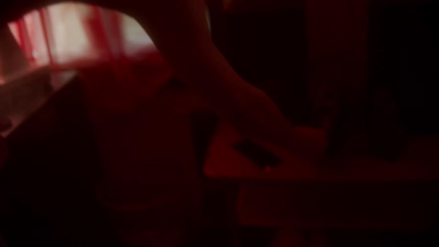 Black man sitting on the bed smokes in his room