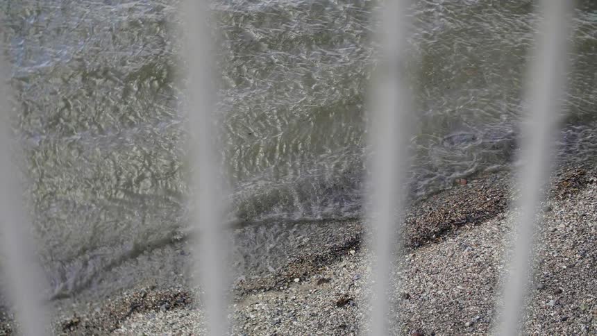 Small waves break against pebble beach