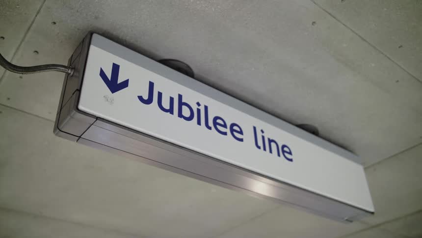 Sign hanging from ceiling directs people to transit line