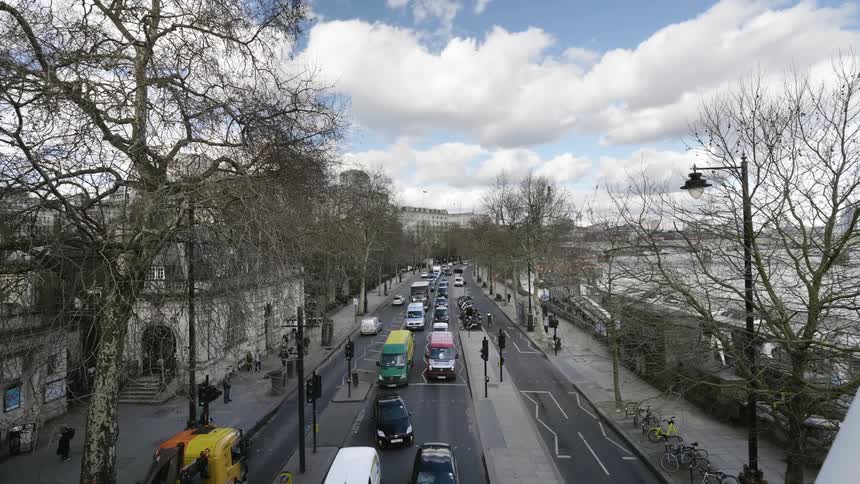 Traffic going through small city street at day