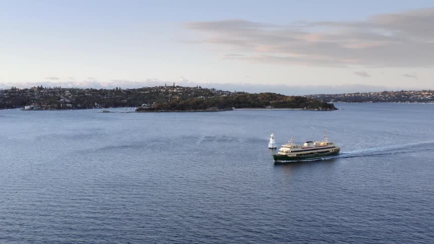 Aerial view of a distant city and a ship traveling across the sea