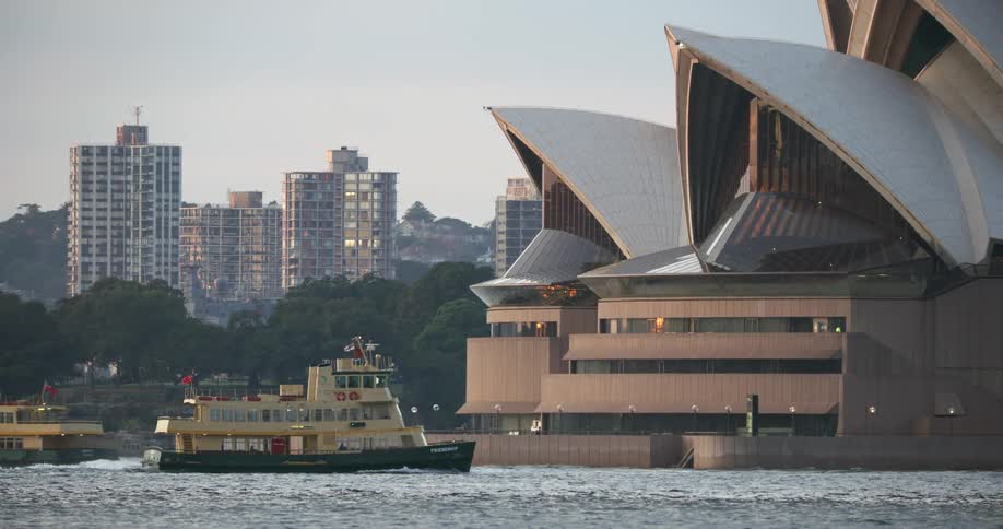 Two boats cruise in a city side river