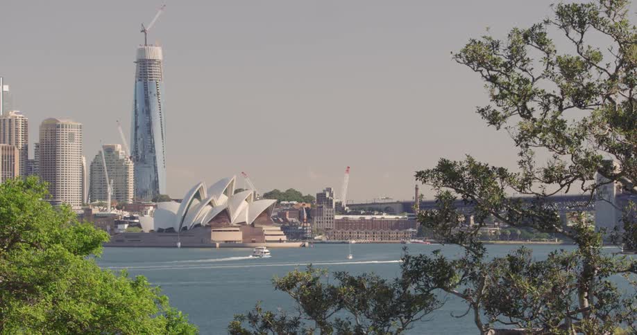 Boats sail past sydney opera house on slightly grey day