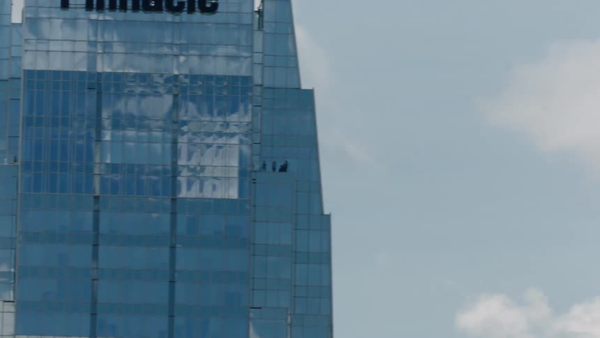 Seven jets fly by a skyscraper in formation