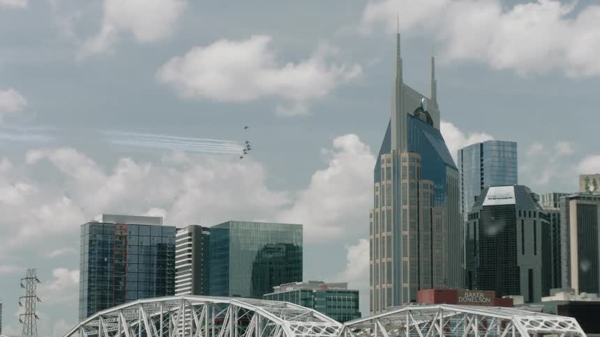 Birds fly past tall modern skyscrapers in a city