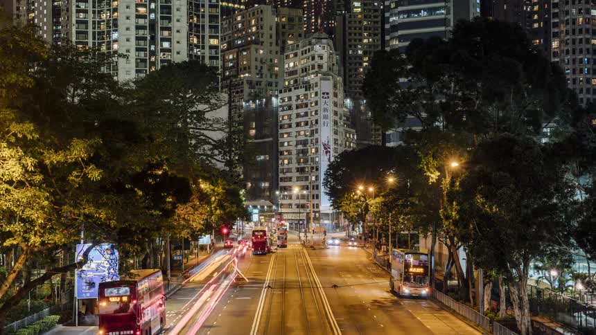 Traffic moves along street to and from downtown skyscrapers at night