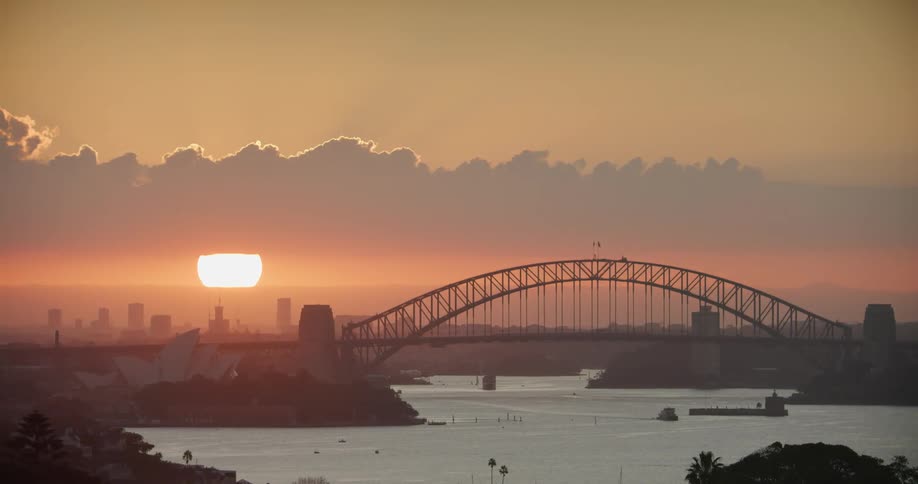 A bridge over a river under a low sun