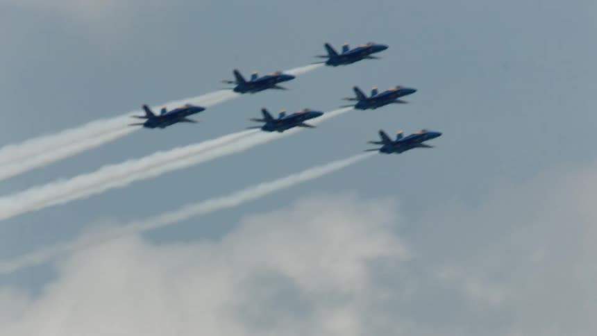 The blue angels squadron fly over a city