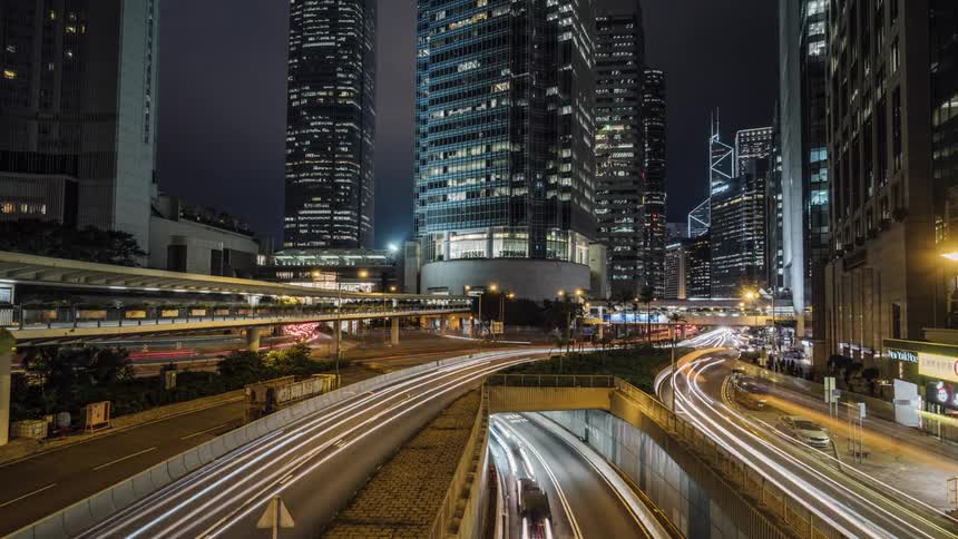 Traffic travels along highway through downtown at night