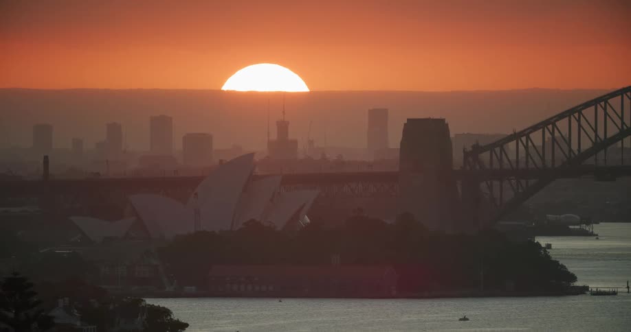 The sun setting over in a landscape shot of the water and city